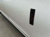 a sticker on the side of a white car that has a clock on it