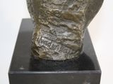 a bronze statue of a man ' s head on a black base