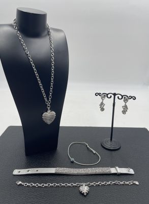un gros plan sur un collier, un bracelet et un porte-bracelet posés sur une table