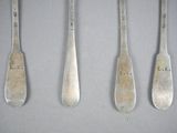 four spoons with the names l r r are lined up on a table