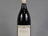 une bouteille de vin posée sur une table à côté d'un verre