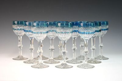 six clear wine glasses are lined up in a row on a white surface
