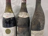 trois bouteilles de vin posées l'une à côté de l'autre sur une table