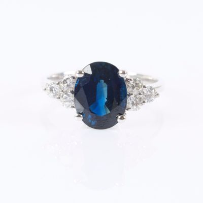 a close up of a blue sapphire and diamond ring on a white background