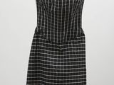 une robe à carreaux noirs et blancs suspendue à un cintre
