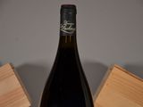 a bottle of wine sitting on a table next to a wooden box