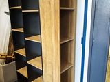 une grande bibliothèque en bois dans un coin de la pièce