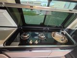 a small stove with two burners in the middle of the kitchen