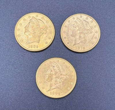 three different types of gold coins on a blue surface