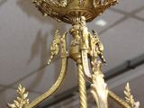 a gold chandelier hanging from the ceiling in a room