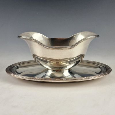 une assiette en argent avec une soucoupe posée dessus