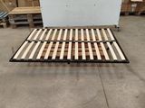 Le cadre du lit est en bois et comporte une armature métallique.