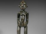 une petite figurine en bronze représentant un homme coiffé d'un chapeau
