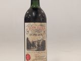 une bouteille de vin rouge posée sur une table blanche