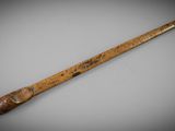 an old wooden stick with a wooden handle sitting on top of a table