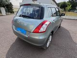 the back end of a small silver car parked in a parking lot