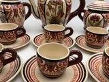 many cups and saucers that are sitting on a table