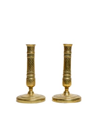 pair of antique brass candlesticks on a white background