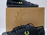 des baskets noires avec un logo vert et jaune sur le côté