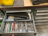 un tiroir rempli d'outils dans un meuble métallique à tiroirs