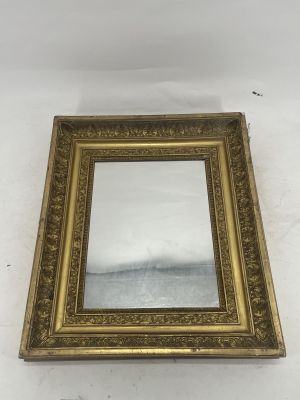 gold framed mirror with ornate design on a white background