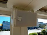a white speaker hanging from the ceiling of a building
