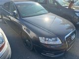 une Audi noire garée sur un parking à côté d'autres voitures