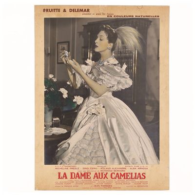 une vieille photo d'une femme en robe blanche tenant une fleur