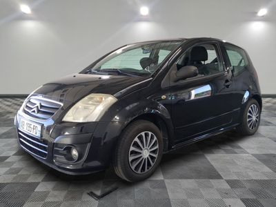 la photo d'une petite voiture noire garée sur un sol en damier