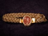 un gros plan d'un bracelet en corde orné d'une pierre rouge au centre