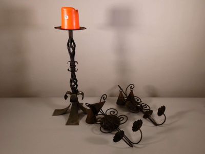 des bougies sont allumées dans un bougeoir posé sur une table blanche