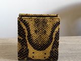 a brown and black snake skin wallet sitting on top of a wooden table