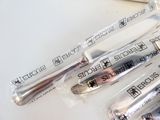 trois cuillères en argent posées sur une table blanche