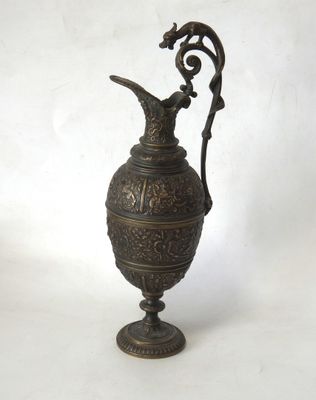 une image représentant un vase en métal muni d'une anse, sur fond blanc