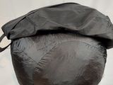 the black bag is sitting on a white surface with a black cover over it