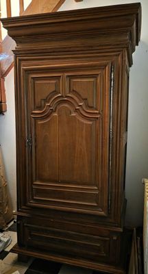 un grand meuble en bois dans le coin d'une pièce