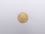 a close up of a gold coin on a white surface