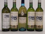 four bottles of wine are lined up in a row on a table