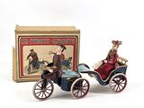toy figurines of a man and a woman in a carriage