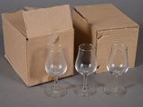 trois verres à vin vides devant une boîte en carton
