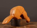 wooden sculpture of a cat on a black base on a wooden table