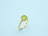 a close up of a ring with a green stone on it