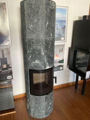une cheminée au milieu du salon, avec une télévision accrochée au mur
