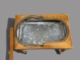 an old wooden table with a metal tray on it