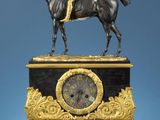 une statue représentant un homme à cheval au sommet d'une horloge