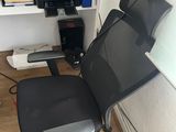 a black office chair sitting in front of a computer desk