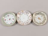 three chinese porcelain plates with floral designs and gold rims