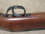 an old wooden gun with a metal ring on top of it
