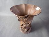 a brown vase with a dragon on it on a gray background