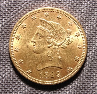 Gros plan sur une pièce d'or ornée d'une tête de femme